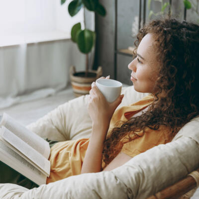 Frau liest auf dem Sofa ein Buch